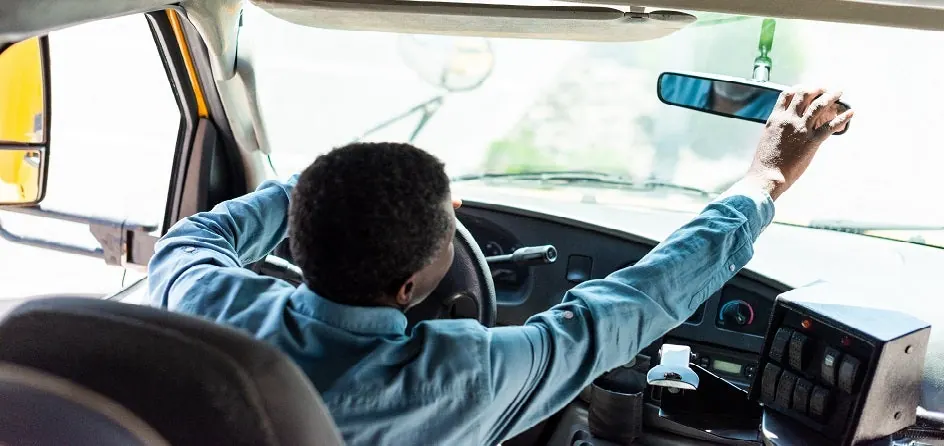 Driver in a truck cabin fitted with fleet tracking